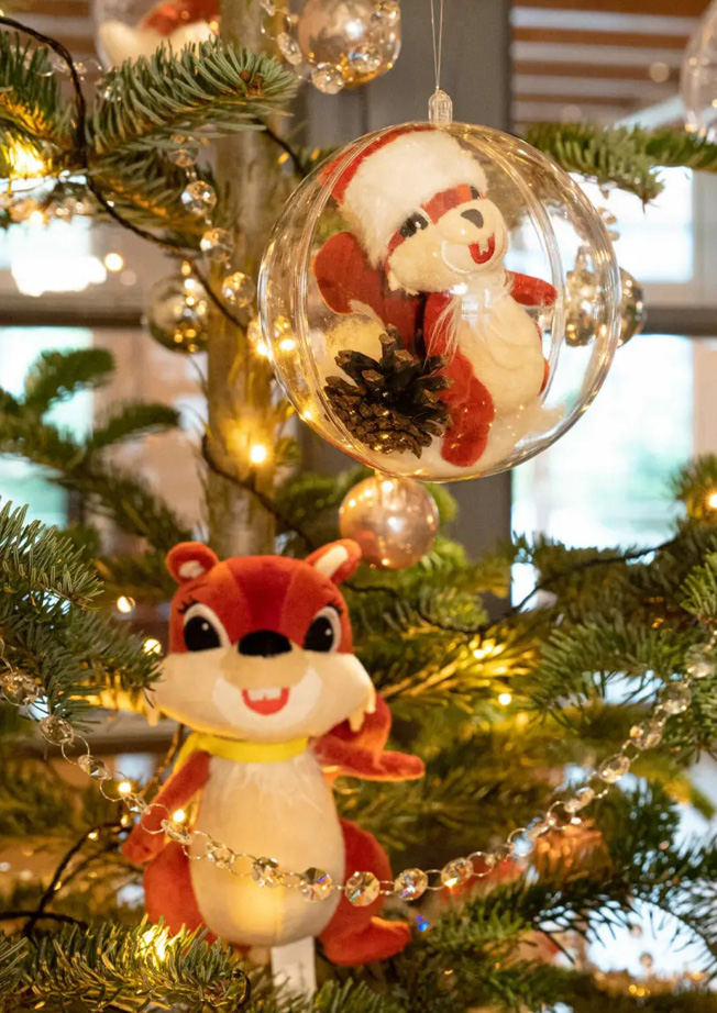 Eine Weihnachtskugel und ein Plüschtier am Weihnachtsbaum