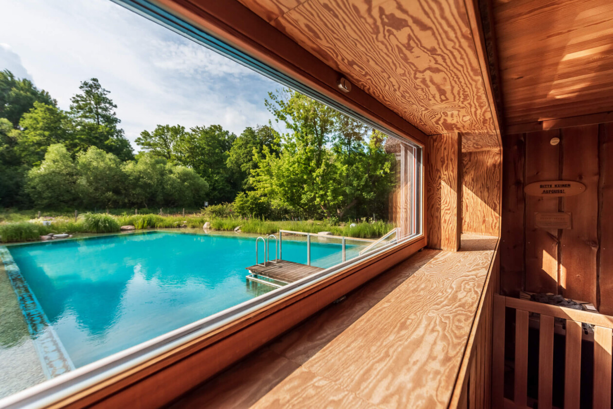 Ausblick aus einer Sauna auf einen Naturbadeteich
