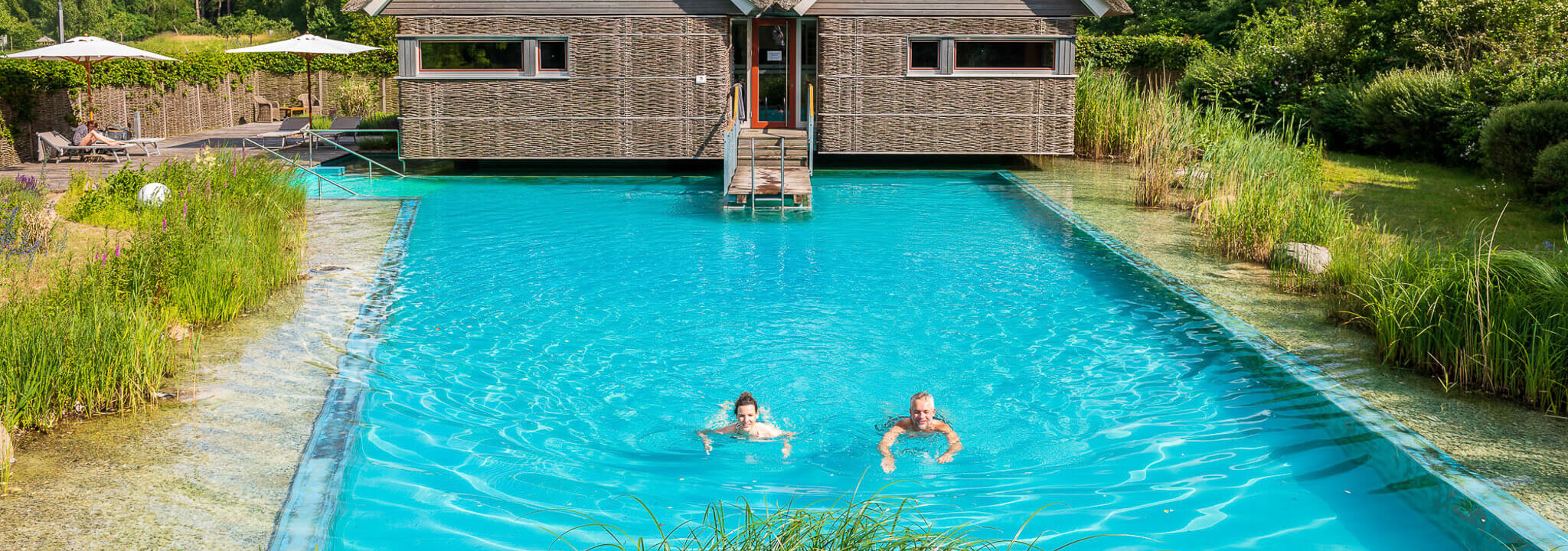 Frau und Mann schwimmen in einem Naturbadeteich