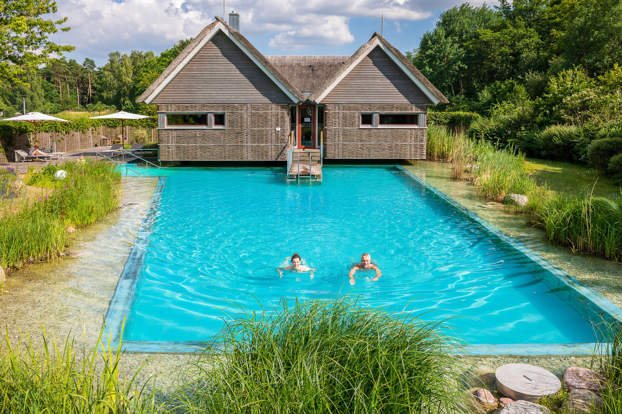 Frau und Mann schwimmen in einem Naturbadeteich