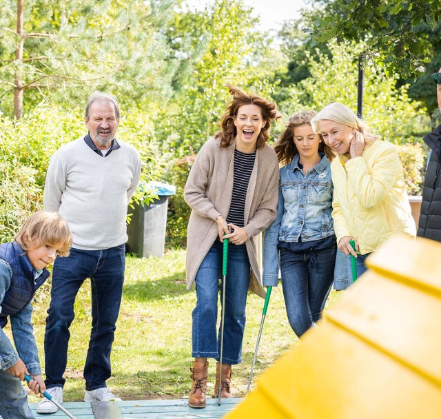 Familie spielt Minigolf