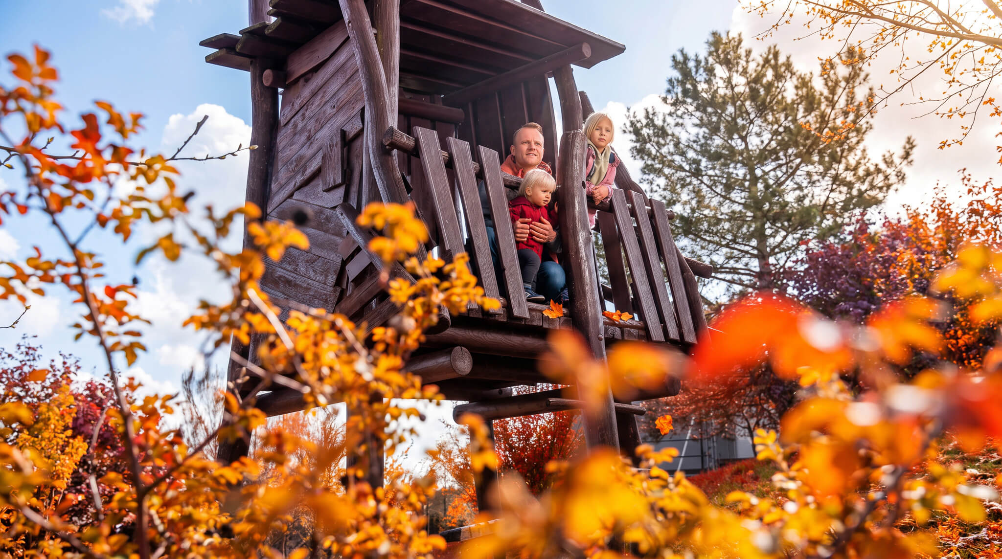 Familie im Herbst auf dem Spielplatz